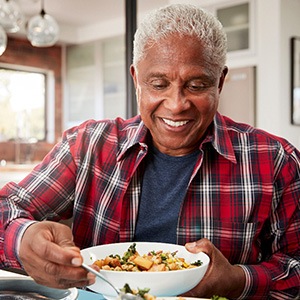 Senior man filling plate at table