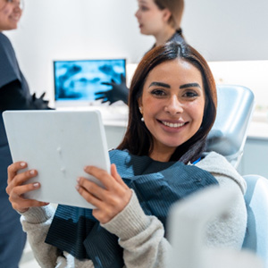 Woman smiling while holding handheld mirror